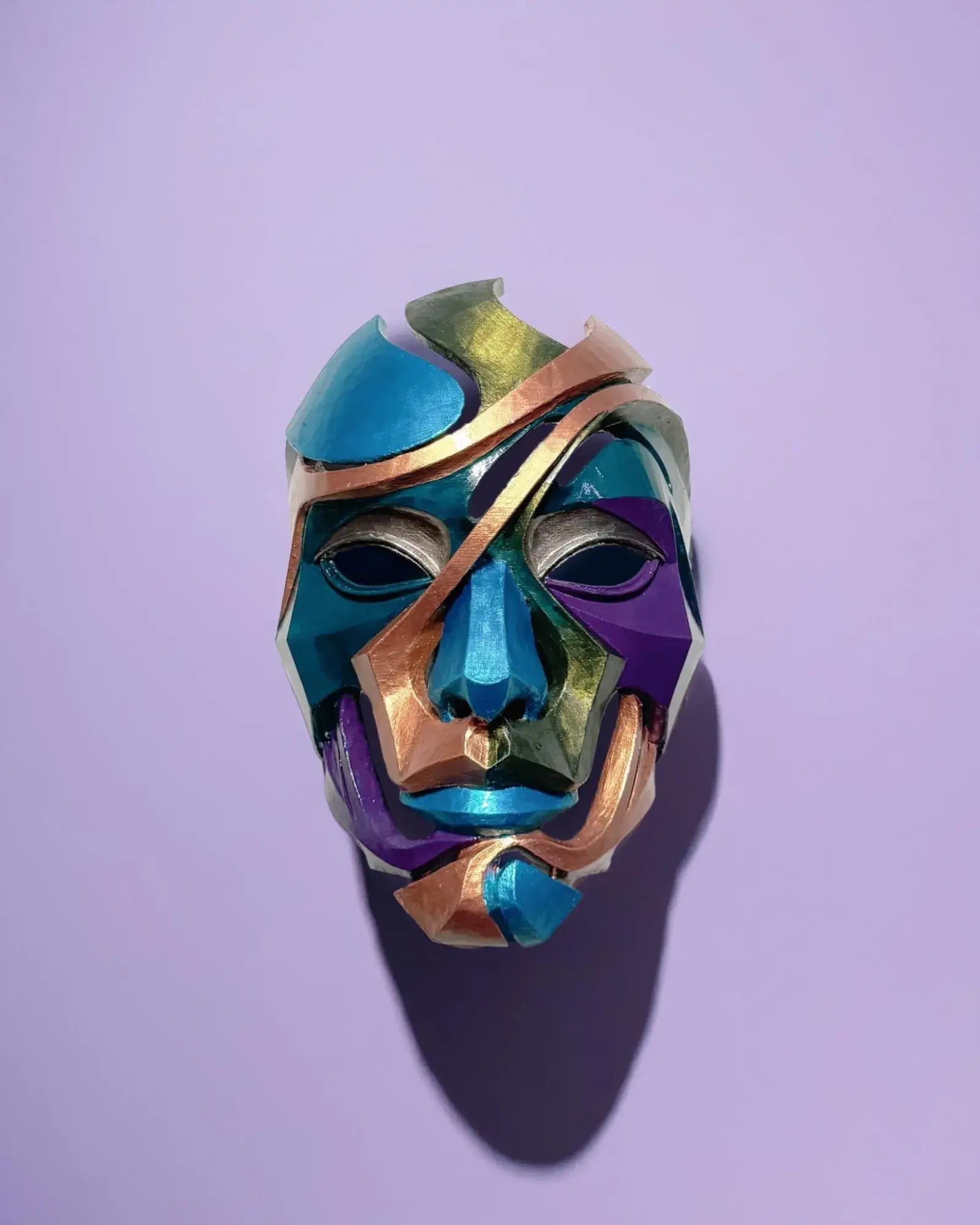 Abstract Colorful Puzzle; Handcrafted Colorful Geometric Face Art mask displayed on a purple background, showcasing vibrant colors.