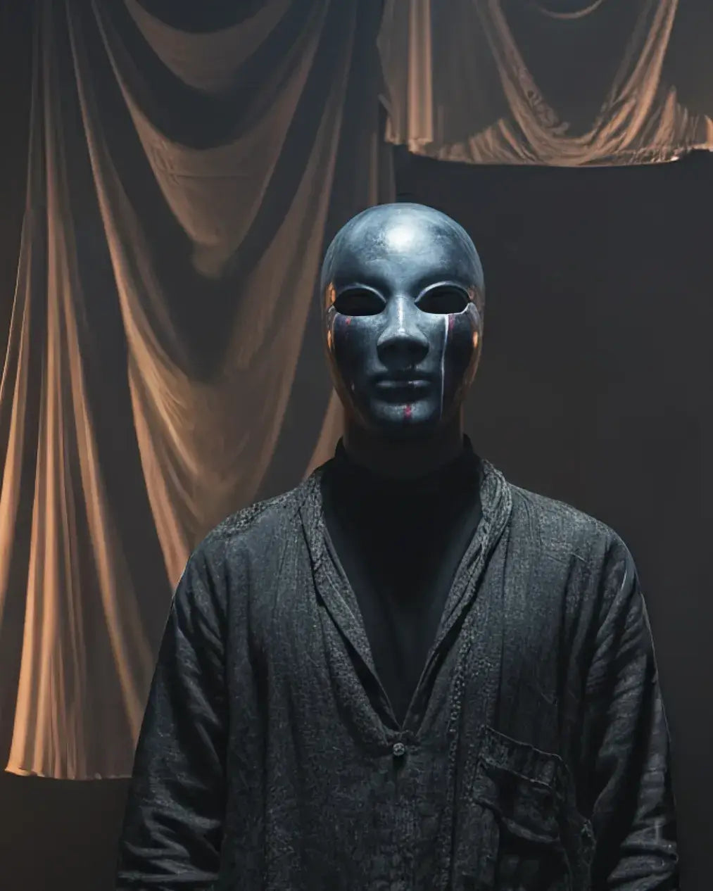Dark Silver Crackle Face with Red Stripes; Abstract Art Mask worn by a figure in dim lighting, showcasing handcrafted Venetian design.