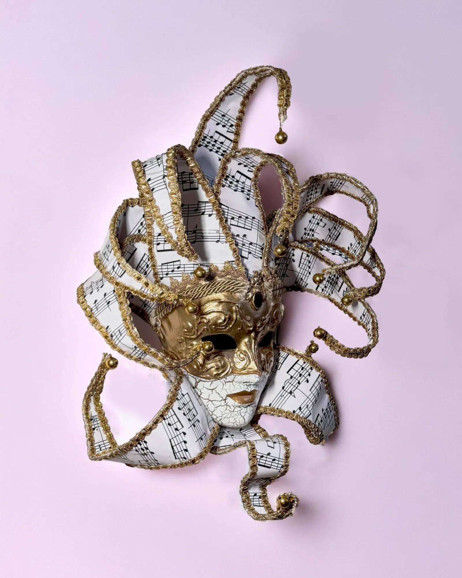 Musical Jester; Gold Full Face with Pink Music Motifs Venetian Sun mask, handcrafted Venetian cosplay fantasy mask on display.