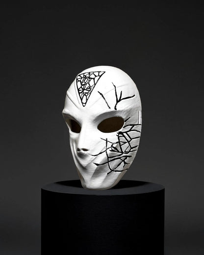 Conspirator Venetian Black Crackle Pattern; Graffiti Style White Mask, handcrafted for cosplay and fantasy, on dark display.