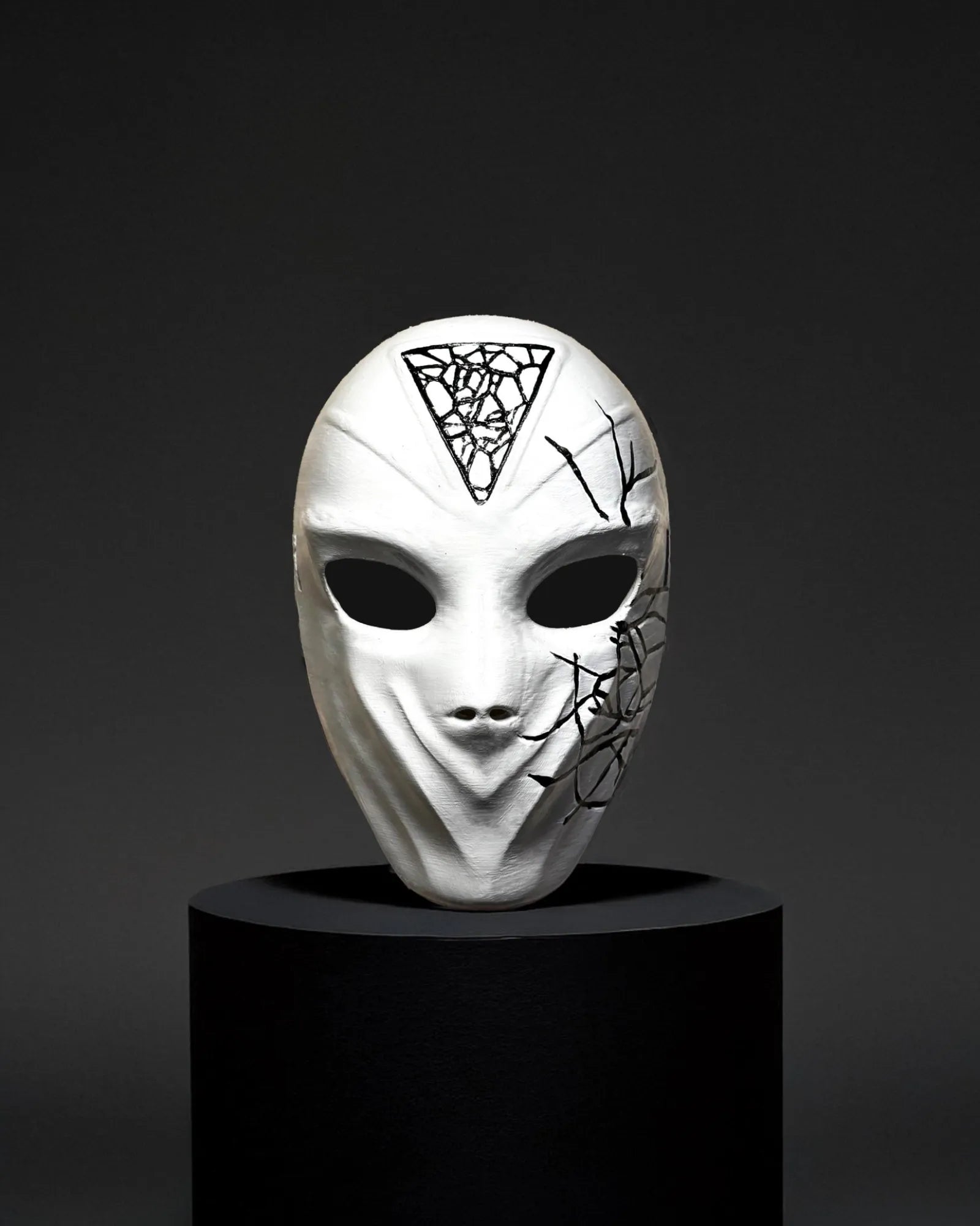 Conspirator Venetian Black Crackle Pattern; Graffiti Style White Mask on display, handcrafted for cosplay and fantasy events.