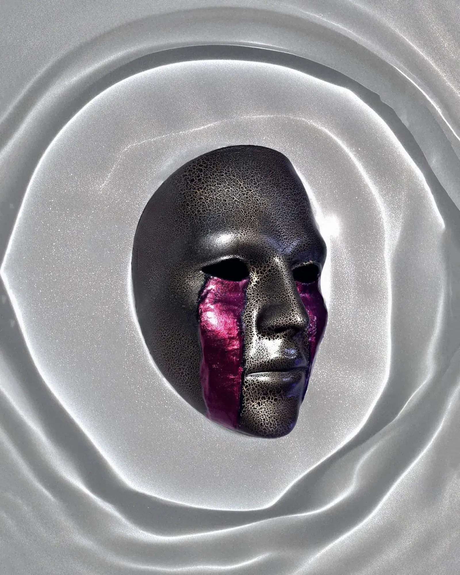 Cracked Black and Gold with Blood Cry Lines; Gothic Art Cosplay Mask displayed against a smooth silver surface.