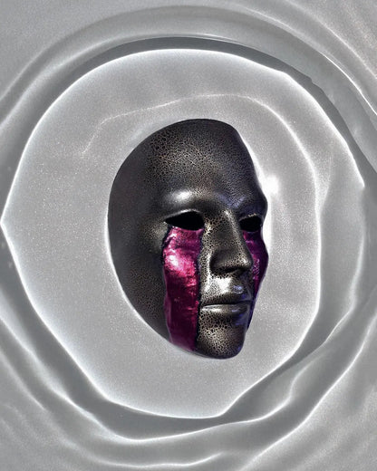 Cracked Black and Gold with Blood Cry Lines; Gothic Art Cosplay Mask displayed against a smooth silver surface.