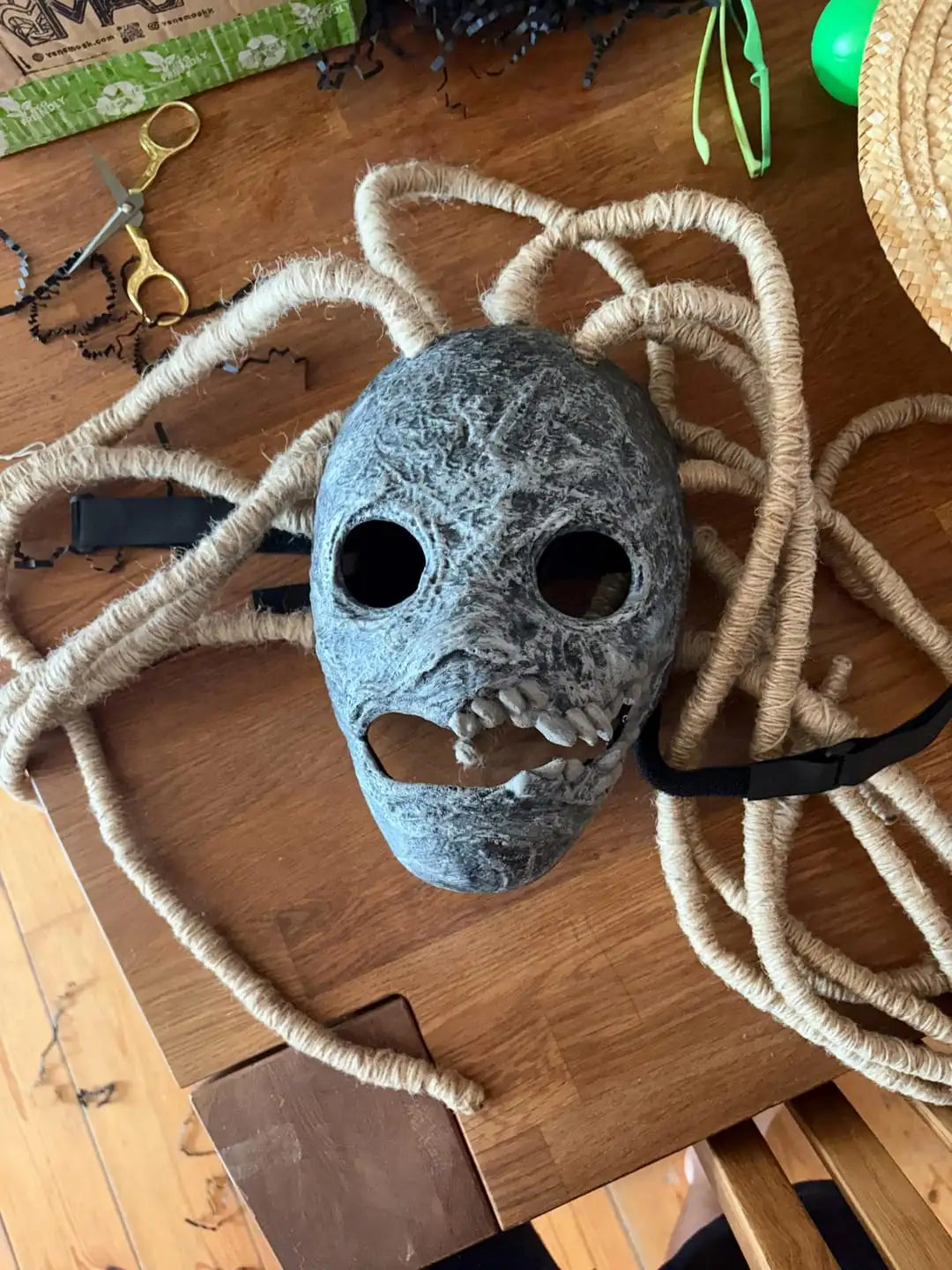 Gray felt mask with black eye holes and spiderweb design