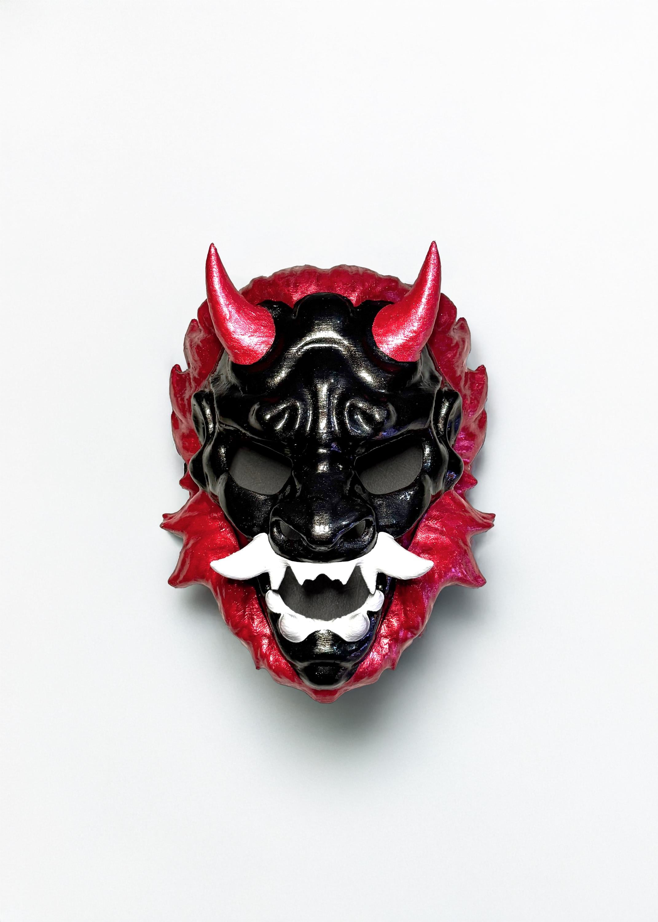 May include: A black and red oni mask with white teeth and horns. The mask has a detailed design and a glossy finish.