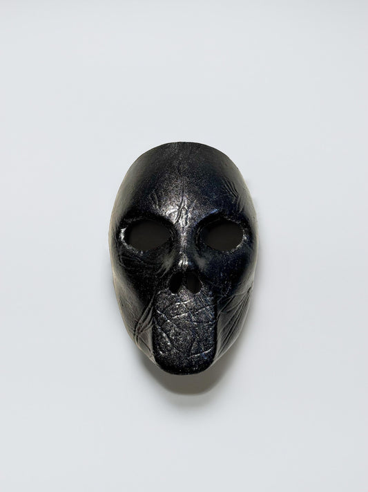 May include: A black mask with a textured surface and two eye holes.