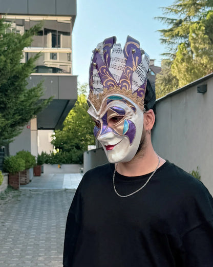 Person wearing Joker Venetian Mask Iconic Techno Purple; Colorful Rio Carnival, Jolly Mask, handcrafted for cosplay and masquerades.