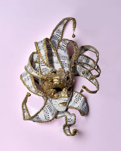 Musical Jester; Gold Full Face with Pink Music Motifs Venetian Sun mask, handcrafted Venetian cosplay fantasy mask on display.