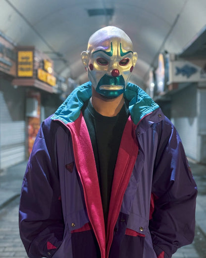 The Bozo Joker; Iconic Villain Face, Handcrafted Detailed Clown mask for Venetian cosplay, brightly colored in an alley setting.