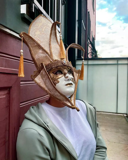 The Popess - Luxurious White and Gold Chic Art Venetian Mask, handcrafted for cosplay and masquerades, worn by an individual outdoors.